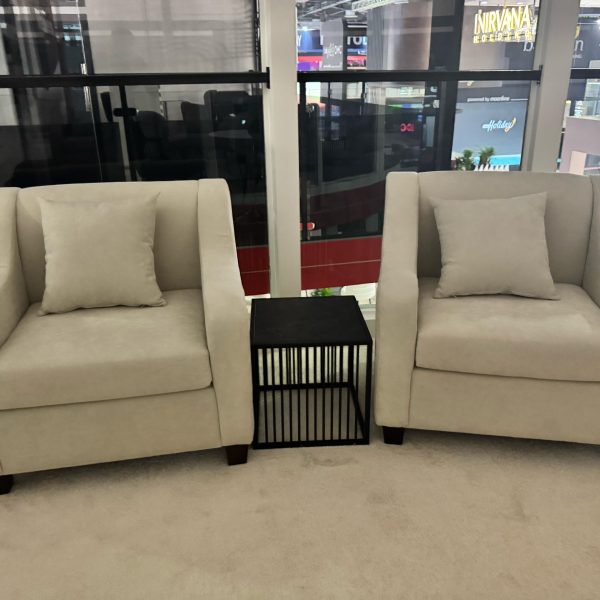 Event walkway with two fabric sofas and black wire coffee table – elegant rental setup in Dubai