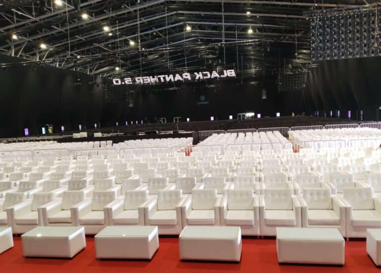 VIP sofas and banquet chairs with black covers arranged for large-scale events in Dubai, available for rent through Qamar Event Rentals.